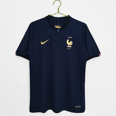 a blue shirt with a gold rooster on it