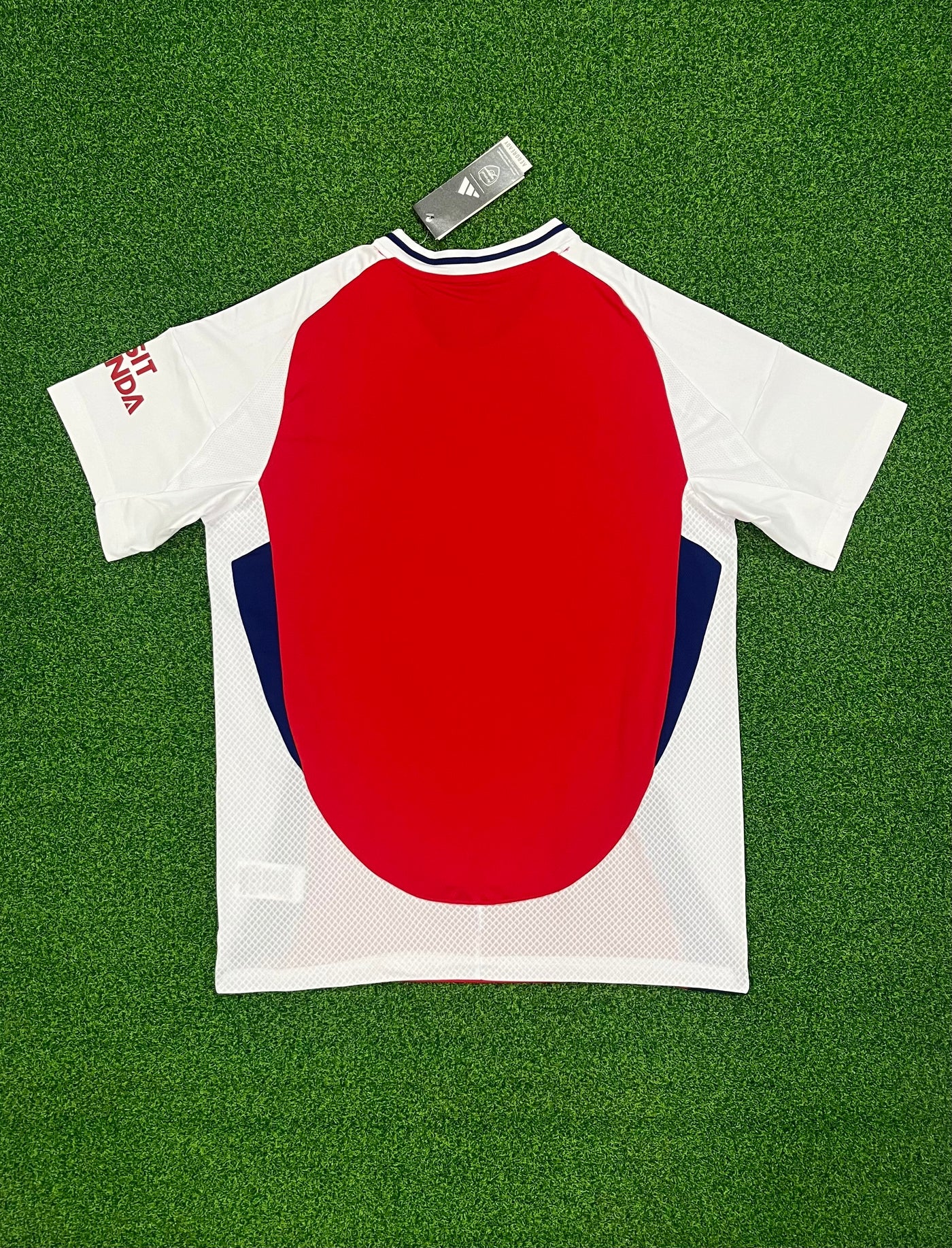 a red, white and blue shirt laying on a green field